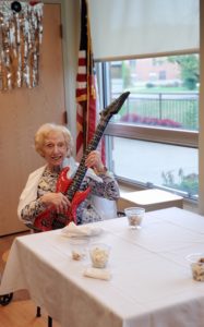 Elderly lady holding a guitar