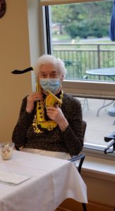 old person wearing a mask and holding a toy instrument